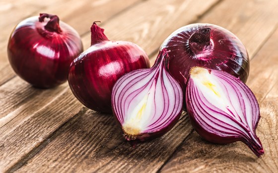 Red onions whole and cut on a table