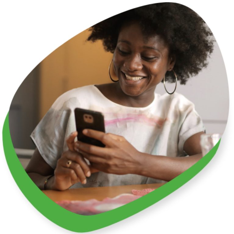 female smiling and holding her phone